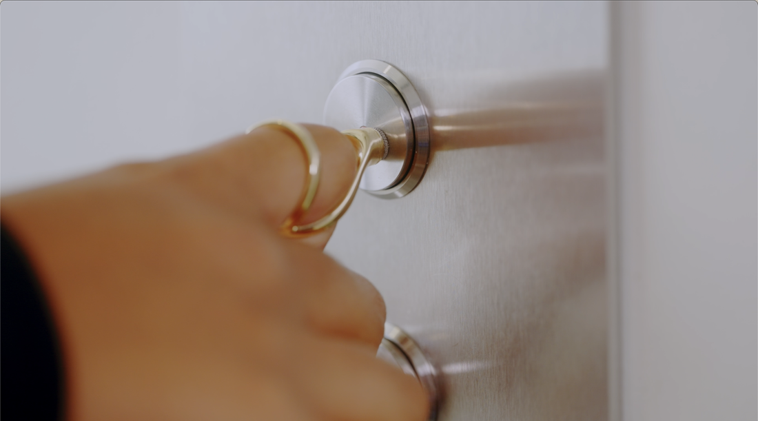 Image of a woman's hand wearing a Pipit Ring and using the ring to press and elevator button.